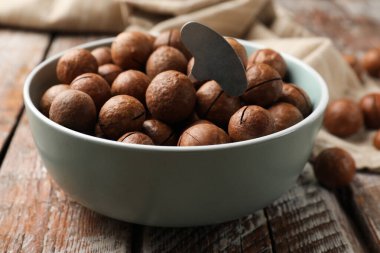 Macadamia fındıkları ve metal anahtar ahşap masada, yakın plan.