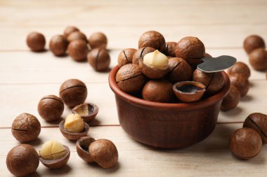 Makadamia fındığı ve metal anahtar açık tahta masada, yakın plan.