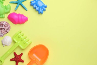 Çocukların plaj oyuncakları, deniz yıldızları ve açık yeşil arka planda deniz kabukları, düz yatış. Metin için boşluk