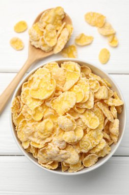 Lezzetli mısır gevrekleri beyaz ahşap masada servis ediliyor.