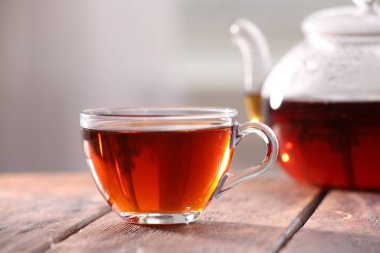 Cam bardakta Aromatik çay ve ahşap masada çaydanlık bulanık arka planda, yakın plan