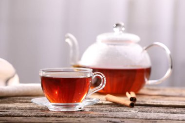 Cam fincanda Aromatik çay ve ahşap masada tarçın çubukları, arka planda ışık, yakın plan