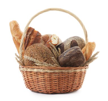 Hasır sepette farklı ekmek türleri ve beyaza izole edilmiş buğday kulakları.