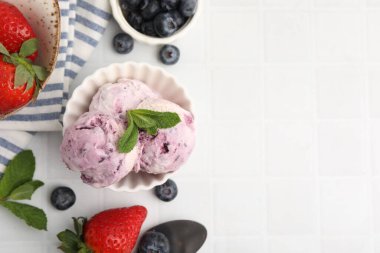 Lezzetli donmuş yoğurt kasede, nane yaprakları ve böğürtlenler beyaz fayanslı masada, düz yerde. Metin için boşluk