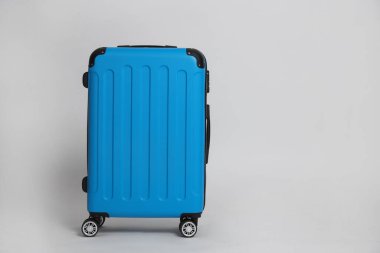 Beyaz arkaplanda açık mavi bir bavul, metin için boşluk