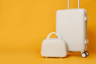 Turuncu arkaplanda farklı bavullar, metin için boşluk