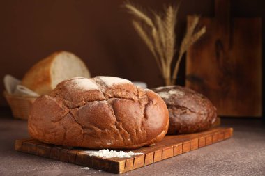 Gri masadaki farklı ekmekler ve çiviler, yakın plan.