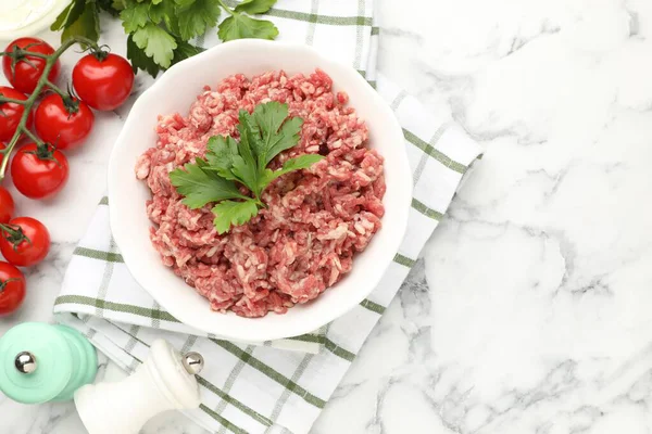 Çiğ kıyma, maydanoz ve domatesler beyaz mermer masada, düz. Metin için boşluk