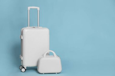 Açık mavi arkaplanda iki farklı şık bavul, metin için boşluk