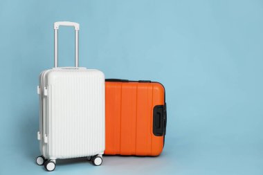 Açık mavi arkaplanda iki farklı şık bavul, metin için boşluk