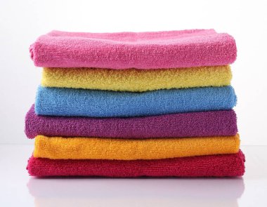 Beyaz üzerine izole edilmiş renkli havlu yığını