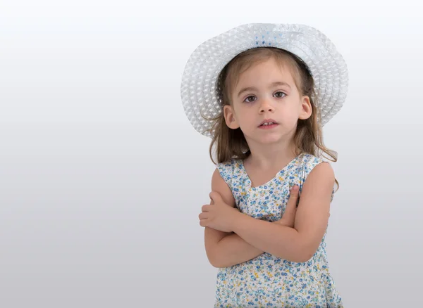 Linda niña con un vestido de flores y un sombrero unen las manos — Foto de Stock