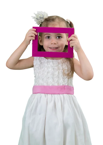 Söt liten flicka med vit klänning innehar en bildram — Stockfoto
