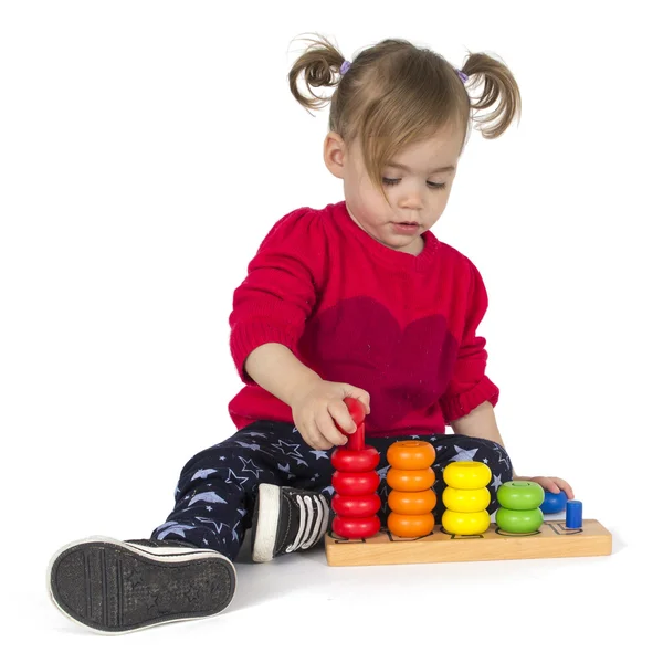 Baby girl playing with rings toy — Stock Photo, Image