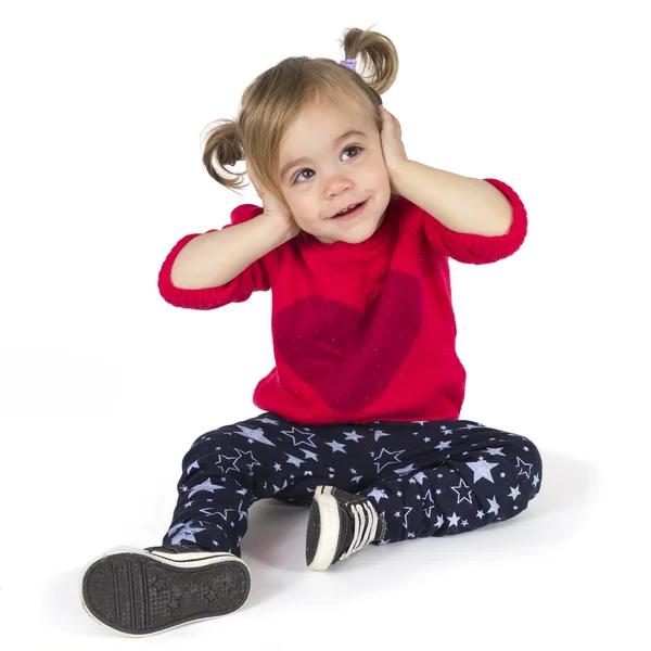 Baby girl sitting and covers her ears — Stock Photo, Image