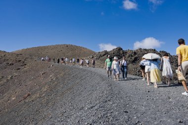Yunanistan 'ın Santorini kenti yakınlarındaki Nea Kameni Adası' nda volkanik yolda yürüyüş yapan bir grup turist
