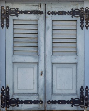 Geleneksel Yıpranmış Açık Mavi Ahşap Pencere Perdeleri 'ne yakın plan Kara Dövülmüş Demir Menteşeli