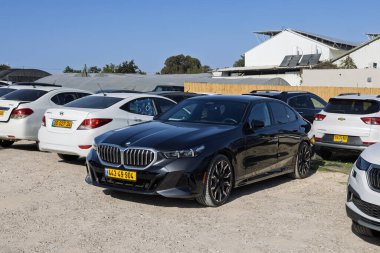 Siyah BMW 5 serisi lüks sedan açık hava çakıl parkında, Ramat Hen, İsrail, 22 Kasım 2025