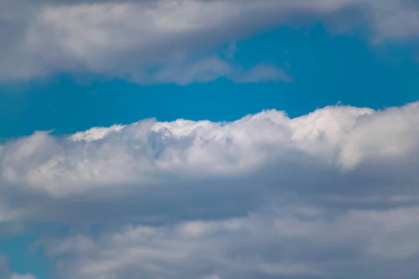 The blue sky is rich in color in clear weather with beautiful lush clouds. The beauty of nature in the fresh air, the layer of atmosphere visible to the eye from bottom to top