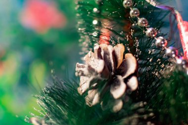 Noel ağacında ilginç Noel oyuncakları. Beyaz renkli Noel aksesuarları yanıp sönen fenerlerin ve ışıkların arasında. Aile tatilleri için şenlikli ve zarif şeyler..