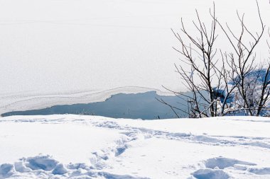 Uçsuz bucaksız kar manzarası. Rusya 'da nehir ve tepeler, arazide beyaz kış, bir sürü yumuşak kar ve buz.