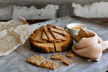 Sağlıklı ve besleyici diyet ekmek. İnce bir malt özü üzerinde susam ve ayçekirdeği. Doğal arı balı ve tahta bir tezgahın yanında.