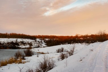 Açık bir günde gün batımında renkli gökyüzü çeşitli renklerle oynar, zıt ve zengin güzel dağ ve şehrin kışın parlaklığının görüntüsü.