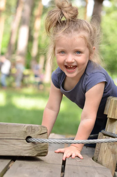 Very happy little girl playing in high wire park — Stock Photo, Image