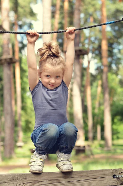 Active girl hanging on a rope in the park — Stock Photo, Image