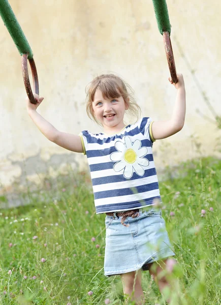 Little girl hanging on gymnastic rings outside — Stock Photo, Image