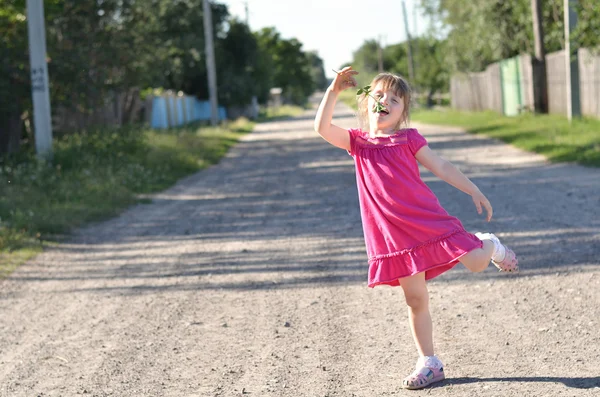 Funny young girl dancing with flower in the street — Stock Photo, Image