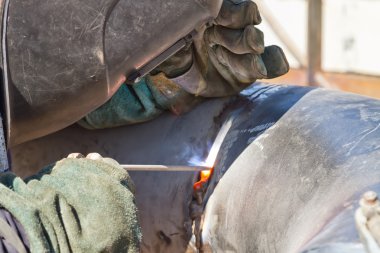 Kaynakçı Kaynak işleri boru hatları paslanmaz çelik üzerinde gerçekleştirir.