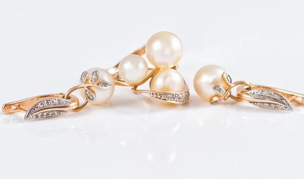 Elegant gold rings and gold earrings with pearls — Stock Photo, Image