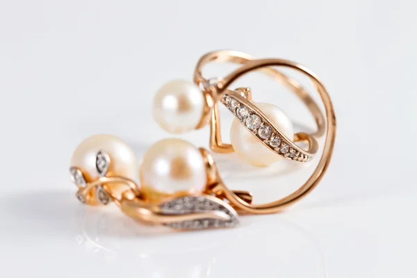 Elegante gouden ringen en gouden oorbellen met parels — Stockfoto