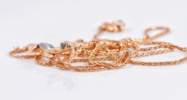 Gold chain and gold pendant in the form of a lizard — Stock Photo, Image