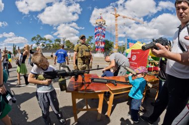 Çocuk bir makineli tüfek ile amaç takes