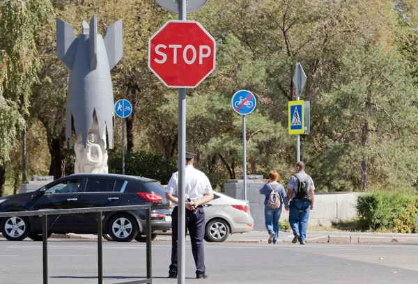 Policjant stoi na rozdrożu, z drążkiem w ręce — Zdjęcie stockowe