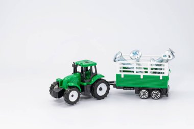Oyuncak yeşil traktör karavanda çeşitli çelik cıvata ve vidalar taşır.