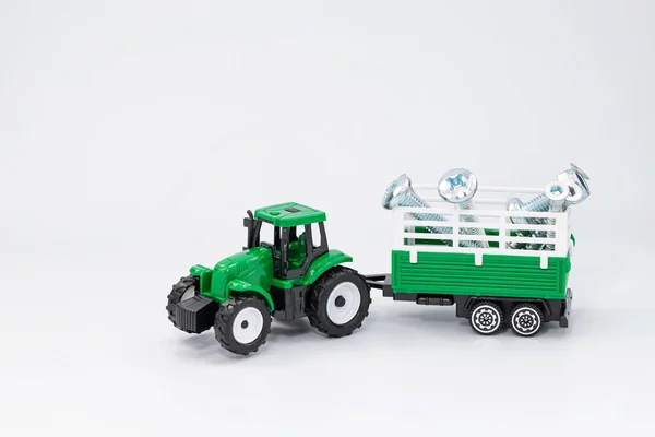 Toy Green Tractor Carries Various Steel Bolts Screws Trailer — Stock Photo, Image