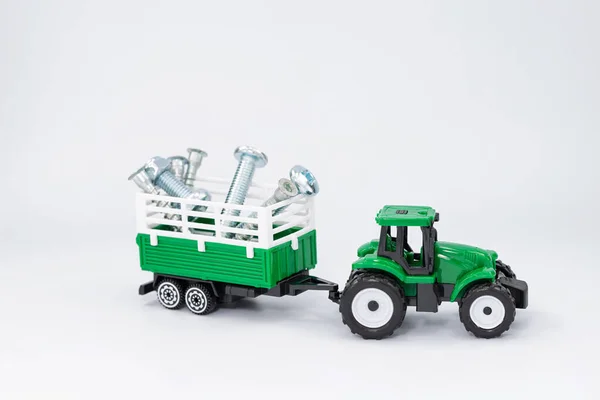 Toy Green Tractor Carries Various Steel Bolts Screws Trailer — Stock Photo, Image