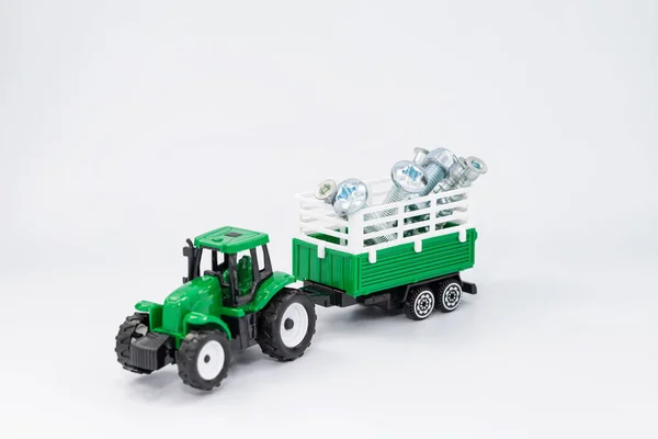 玩具绿色拖拉机装有各种钢制螺钉和螺丝 — 图库照片