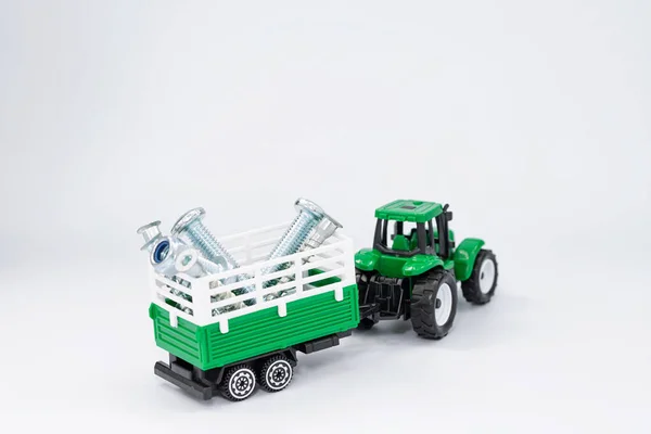 Toy Green Tractor Carries Various Steel Bolts Screws Trailer — Stock Photo, Image