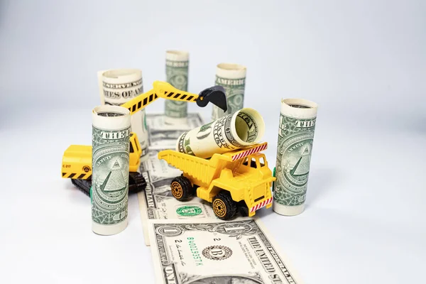 おもちゃの建設機械は ドル紙幣から新しい高速道路を構築します — ストック写真