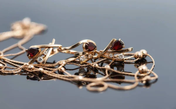 구슬이 금사슬 목걸이 루비가 반지와 귀걸이가 반사되는 표면에 — 스톡 사진