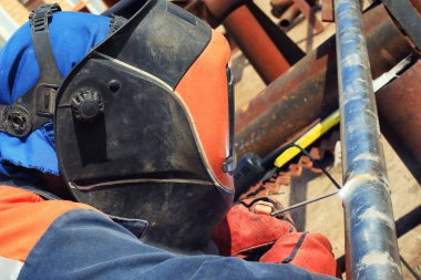 Kaynakçılık, yeni petrol arıtma tesisatı boru hattının elle kaynaklama kullanılarak kurulumunda çalışır.