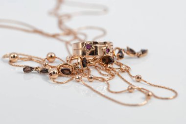 Yıldızlar ve yakut küpeler şeklinde yakutlu bir yüzük beyaz yüzeye yansıyor.