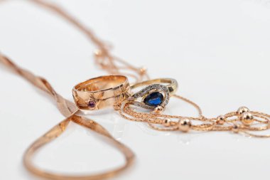 İki farklı şekilli altın yüzük ve iki farklı şekilli altın zincir.