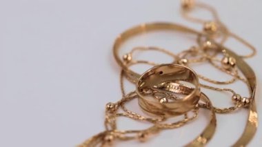 Altın yüzükler, küpeler ve zincirler eksenlerinin etrafında dönüyorlar.