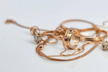 Yıldızlar şeklinde altın bir yüzük çeşitli şekillerde yakutlar ve altın zincirlerle süslenmiş ve beyaz yansıtıcı bir yüzey üzerine örülmüş.