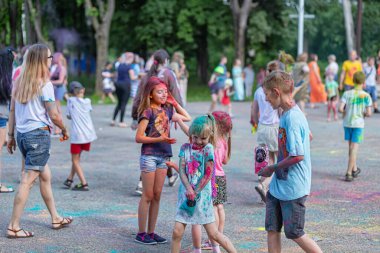 Açık hava boya festivaline boyalı yüzler ve kıyafetlerle katılan mutlu katılımcılar. 20 Haziran 2021 Essentuki, Rusya.